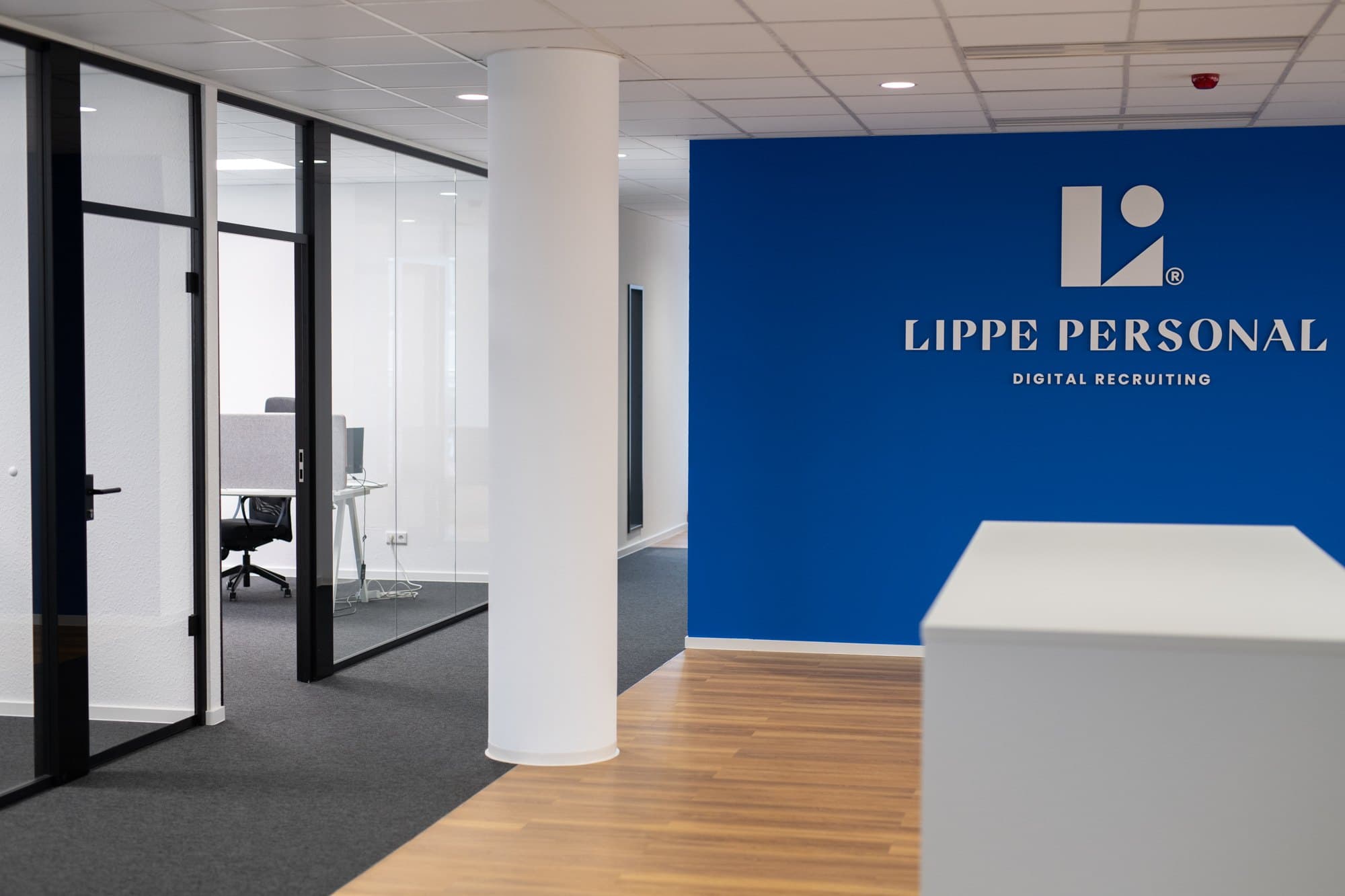 Empfangsbereich im Büro von Lippe Personal mit blauer Logowand